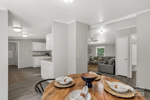 a kitchen with stainless steel appliances kitchen island granite countertop a dining table and chairs