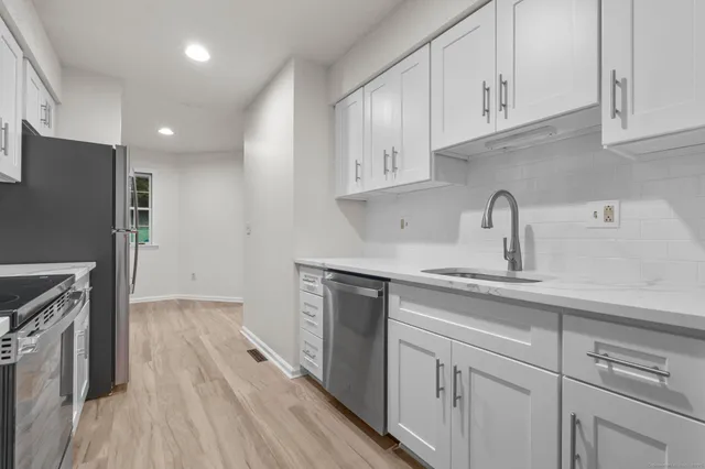 a kitchen with cabinets appliances and a sink