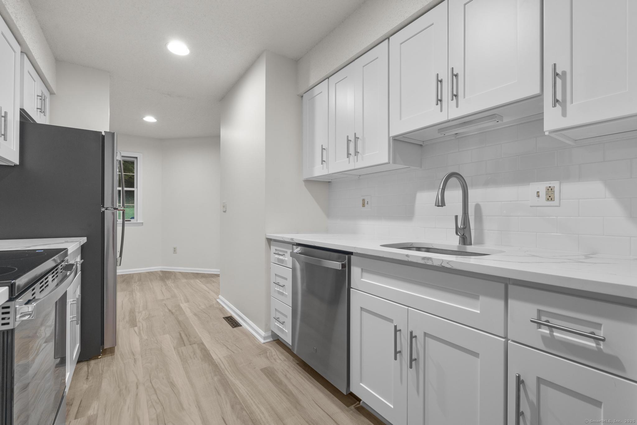 98 Crown Ridge Newington, CT 06111 - Photo 11 of 37 a kitchen with cabinets appliances and a sink