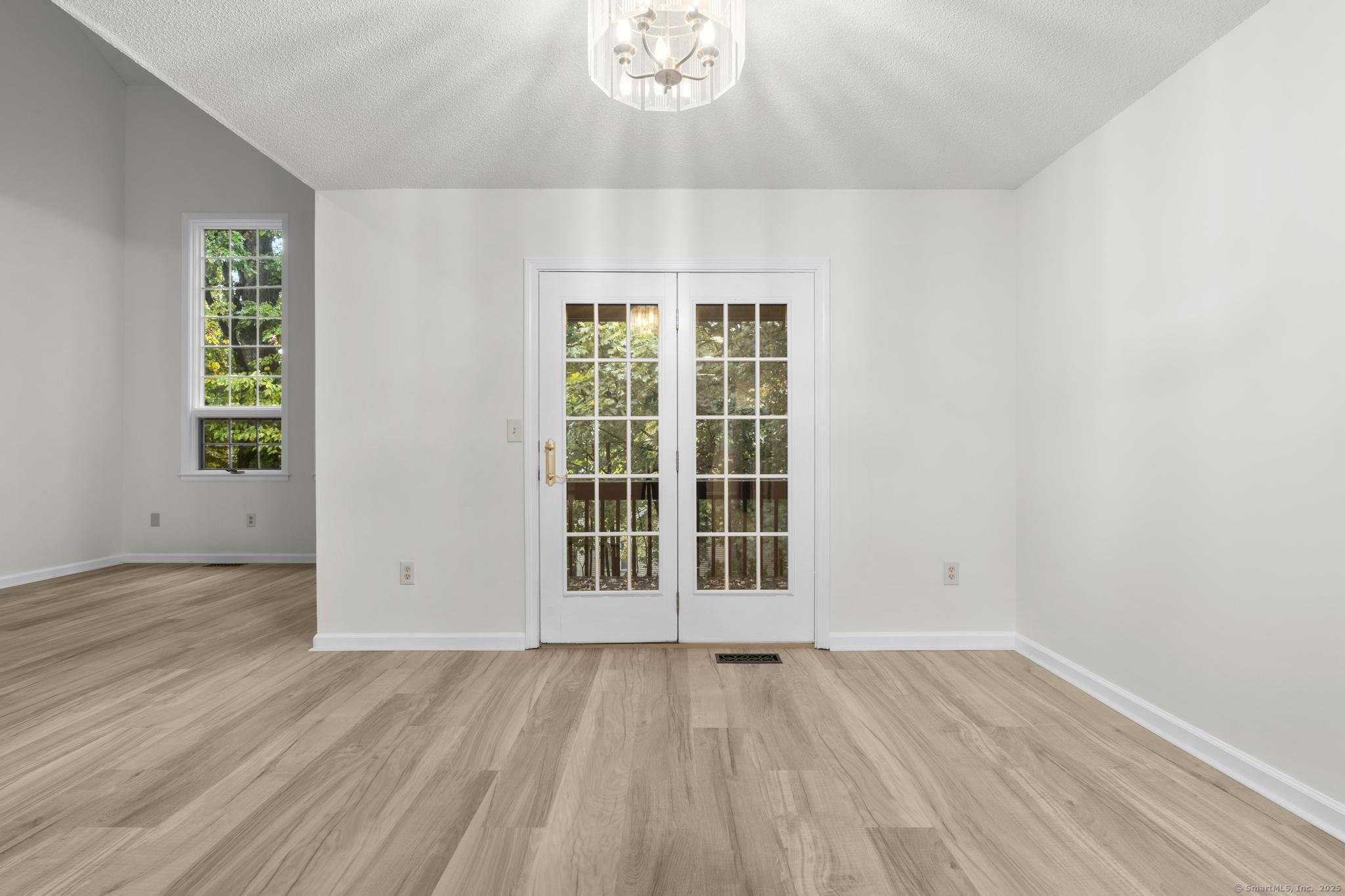 98 Crown Ridge Newington, CT 06111 - Photo 12 of 37 an empty room with wooden floor and windows