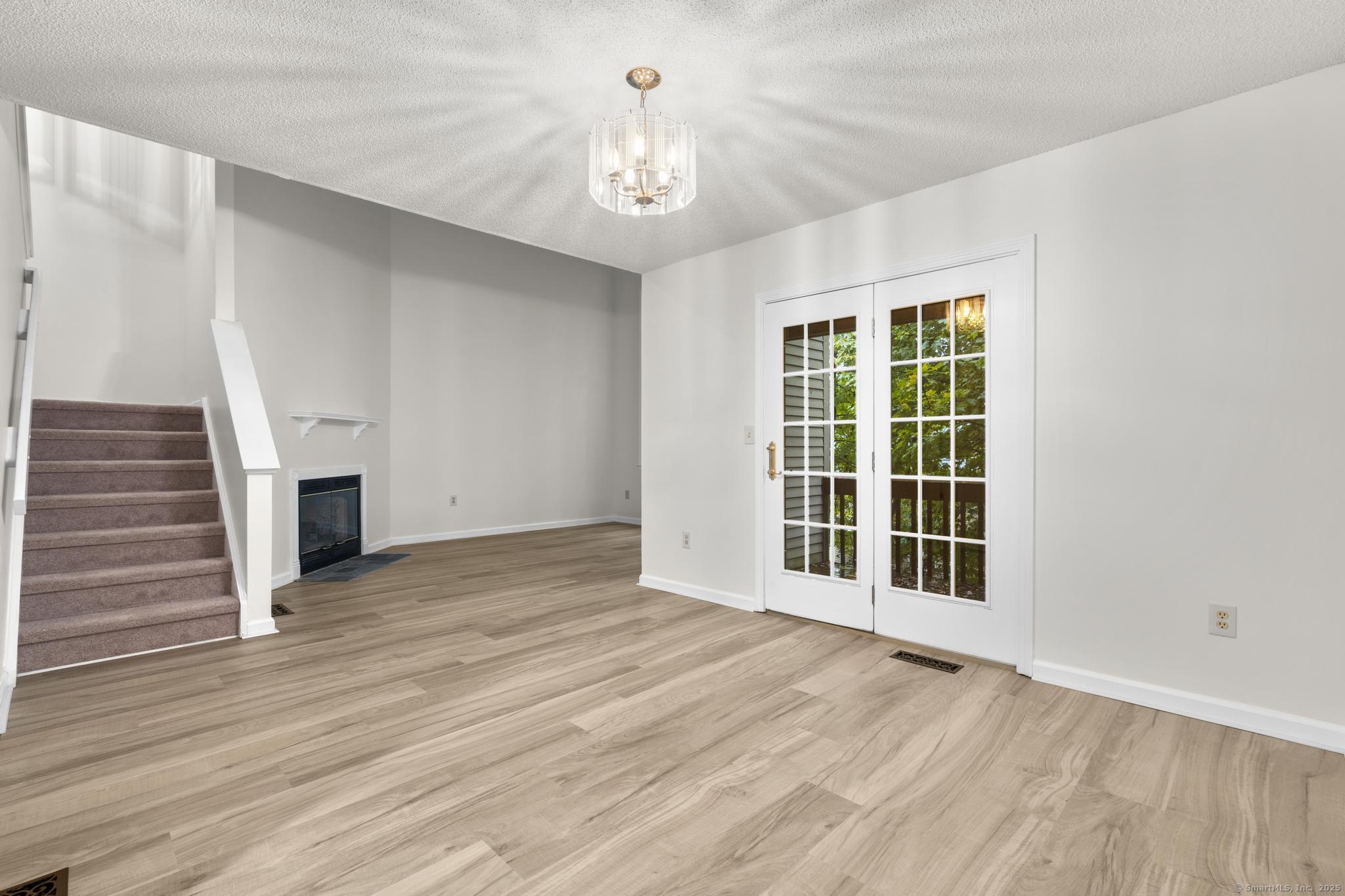 98 Crown Ridge Newington, CT 06111 - Photo 14 of 37 a view of a livingroom with wooden floor and a ceiling fan