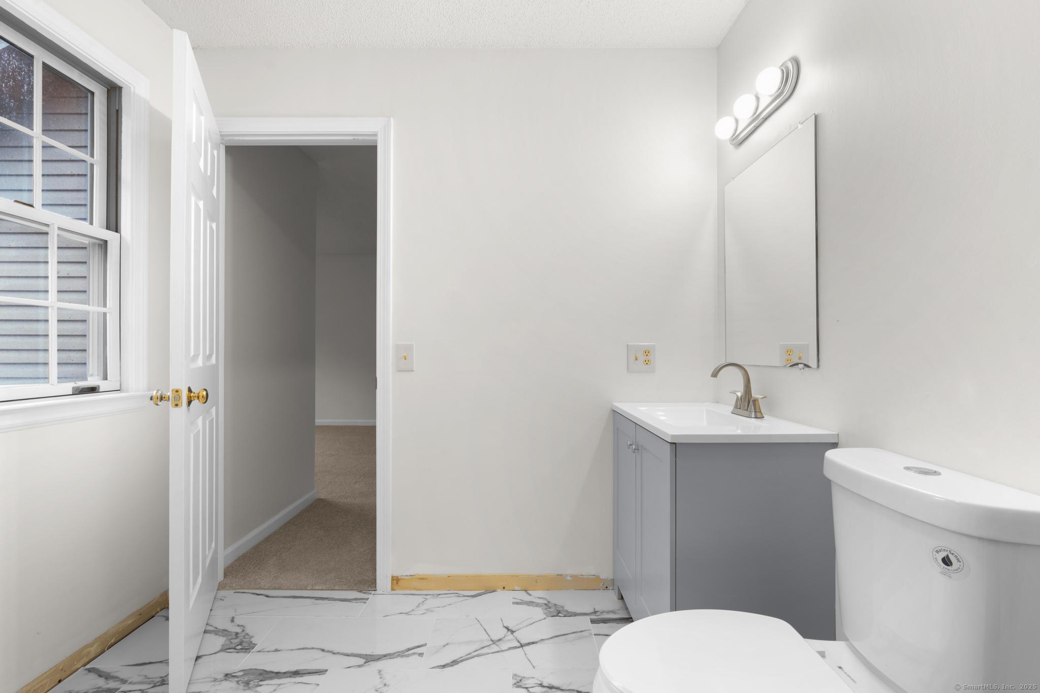 98 Crown Ridge Newington, CT 06111 - Photo 27 of 37 a bathroom with a toilet a sink and mirror