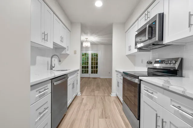 a kitchen with stainless steel appliances granite countertop a sink and stove top oven