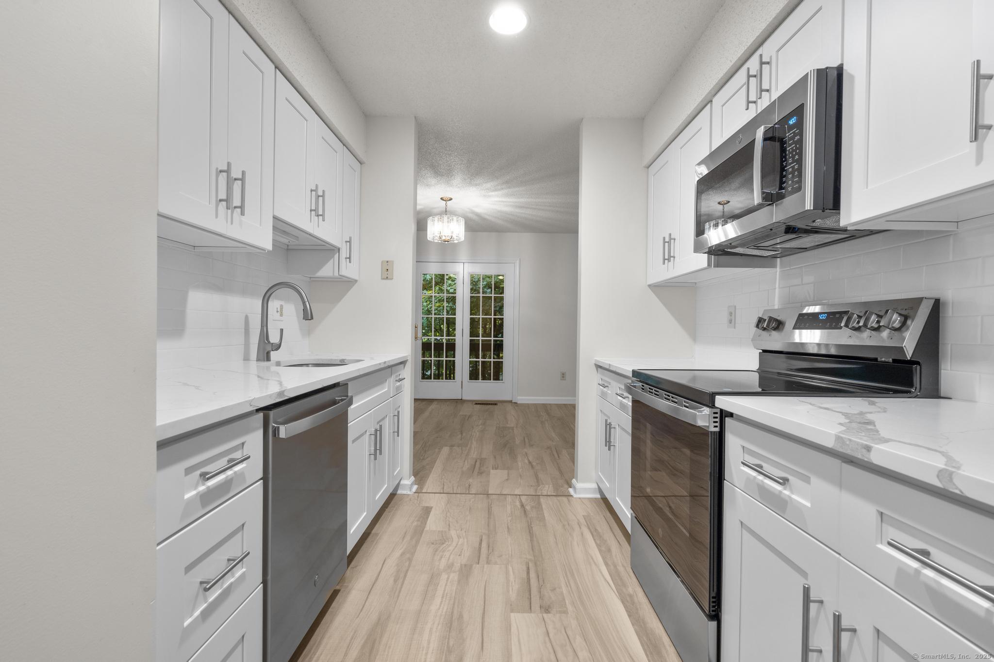 98 Crown Ridge Newington, CT 06111 - Photo 9 of 37 a kitchen with stainless steel appliances granite countertop a sink and stove top oven