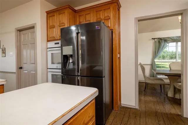 a kitchen with stainless steel appliances a table chairs and a refrigerator