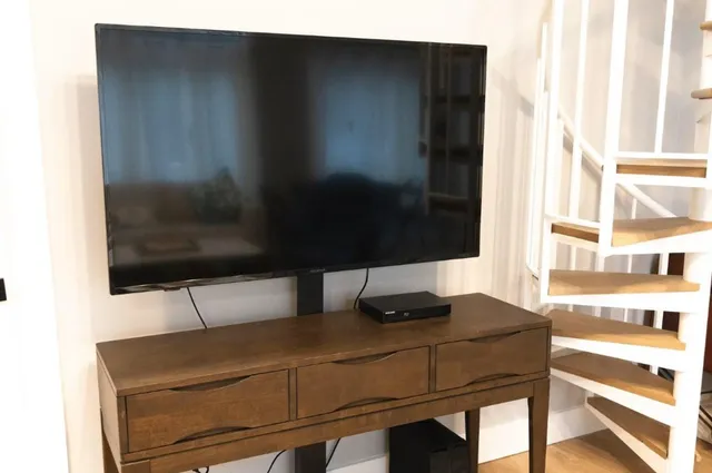 a living room with a chair and a flat screen tv