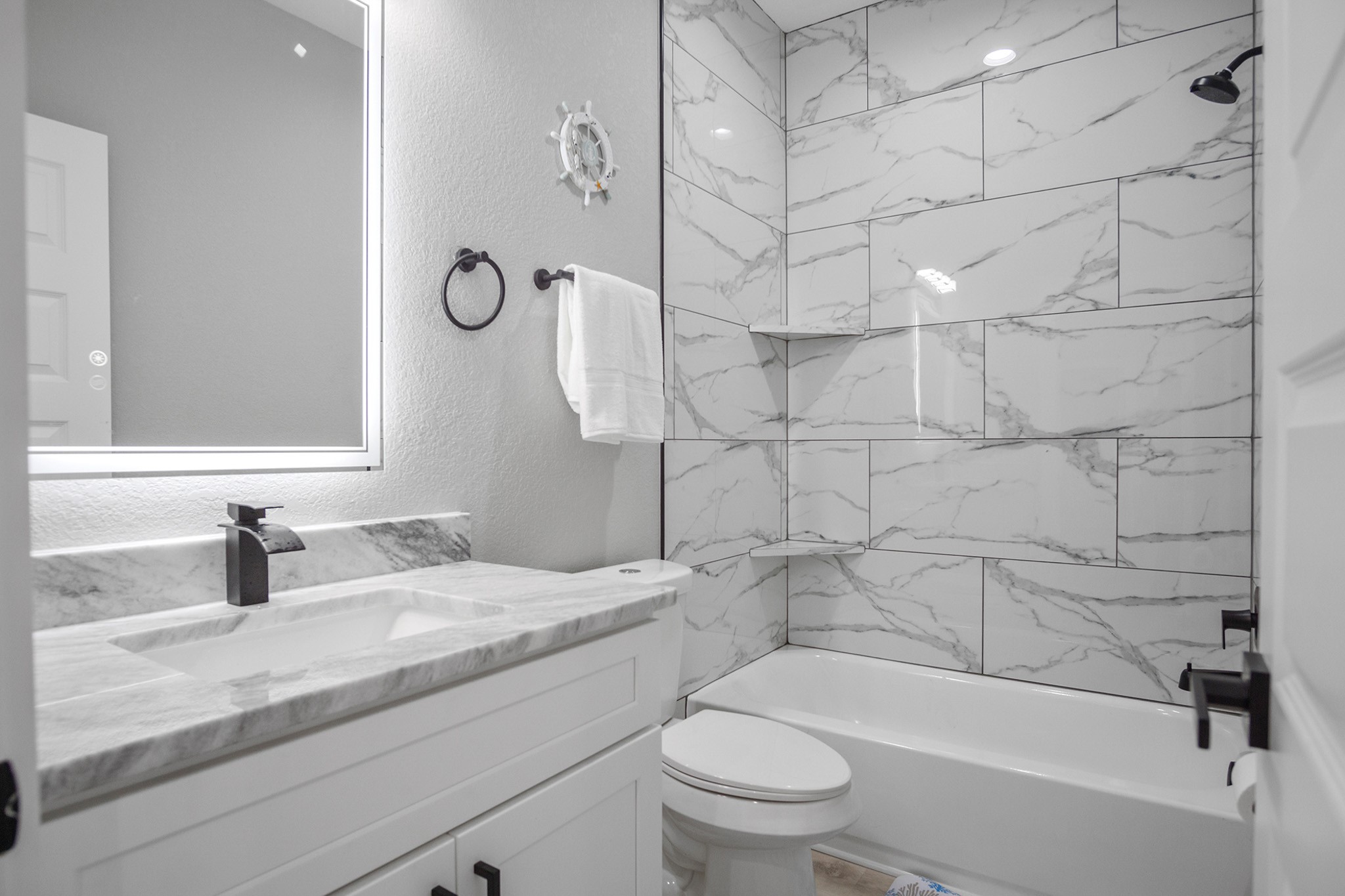 1297 Mabry Port Bolivar, TX 77650 - Photo 14 of 38 a bathroom with a granite countertop bathtub shower sink vanity and toilet