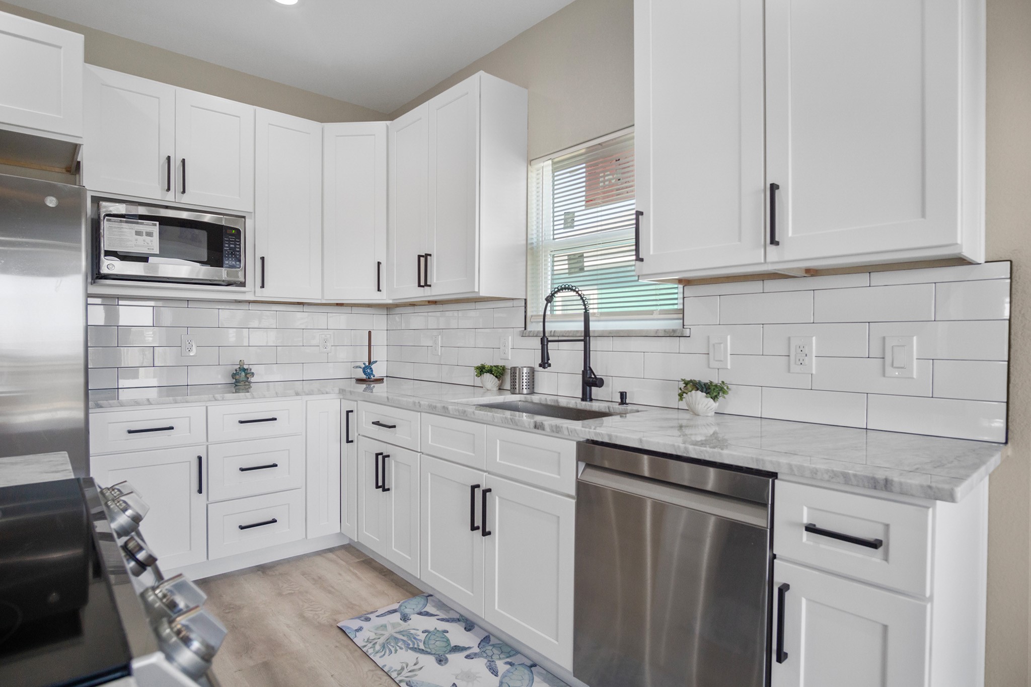 1297 Mabry Port Bolivar, TX 77650 - Photo 9 of 38 a kitchen with stainless steel appliances granite countertop white cabinets a sink and dishwasher