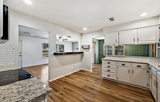 a kitchen with stainless steel appliances kitchen island granite countertop a refrigerator and a stove top oven