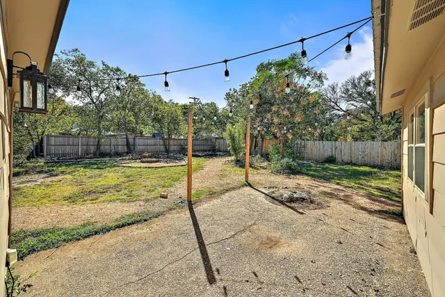 a view of a yard with a wooden fence