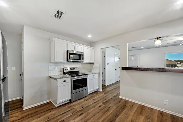 a kitchen with stainless steel appliances granite countertop a stove a sink and a refrigerator