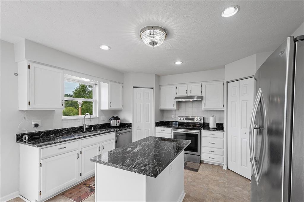 482 Shelbourne Drive Pittsburgh, PA 15239 - Photo 12 of 49 a kitchen with stainless steel appliances granite countertop a sink stove refrigerator and cabinets