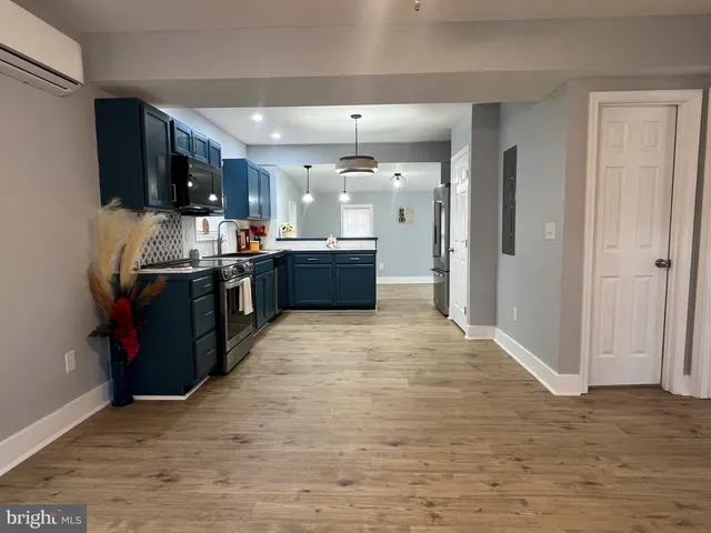 a large kitchen with stainless steel appliances kitchen island granite countertop a refrigerator and a stove top oven