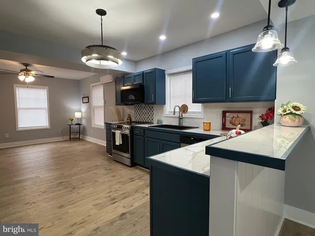 a kitchen with stainless steel appliances granite countertop a refrigerator a sink and a wooden cabinets