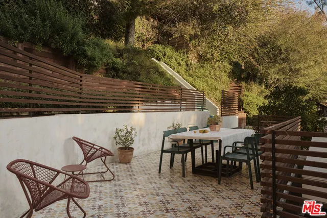 a balcony with wooden floor and outdoor seating