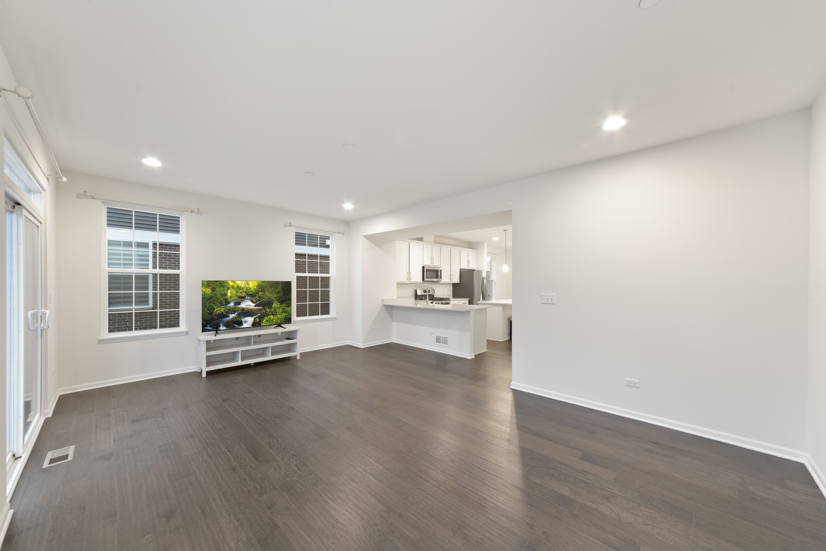 4431 Monroe Court Naperville, IL 60564 - Photo 3 of 13 a view of an empty room with a window and wooden floor