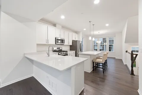 a kitchen with appliances a sink a counter top space and cabinets
