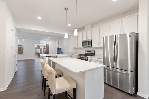 a kitchen with a refrigerator a dining table and chairs