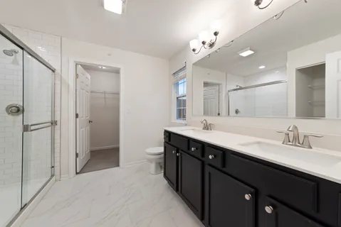 a spacious bathroom with a double vanity sink mirror and shower