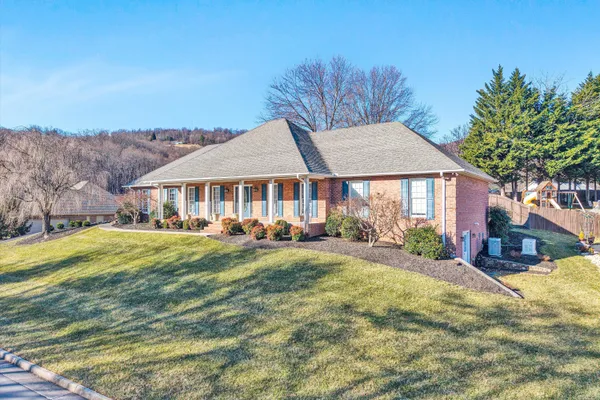 a view of a house with pool and trees in the background
