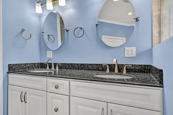 a kitchen with granite countertop white cabinets and a sink