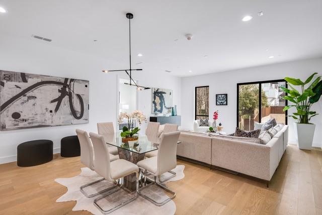 3601 Routh Street, Unit 2E Dallas, TX 75219 - Photo 2 of 14 Dining space with an inviting chandelier, light wood-style flooring, visible vents, and recessed lighting