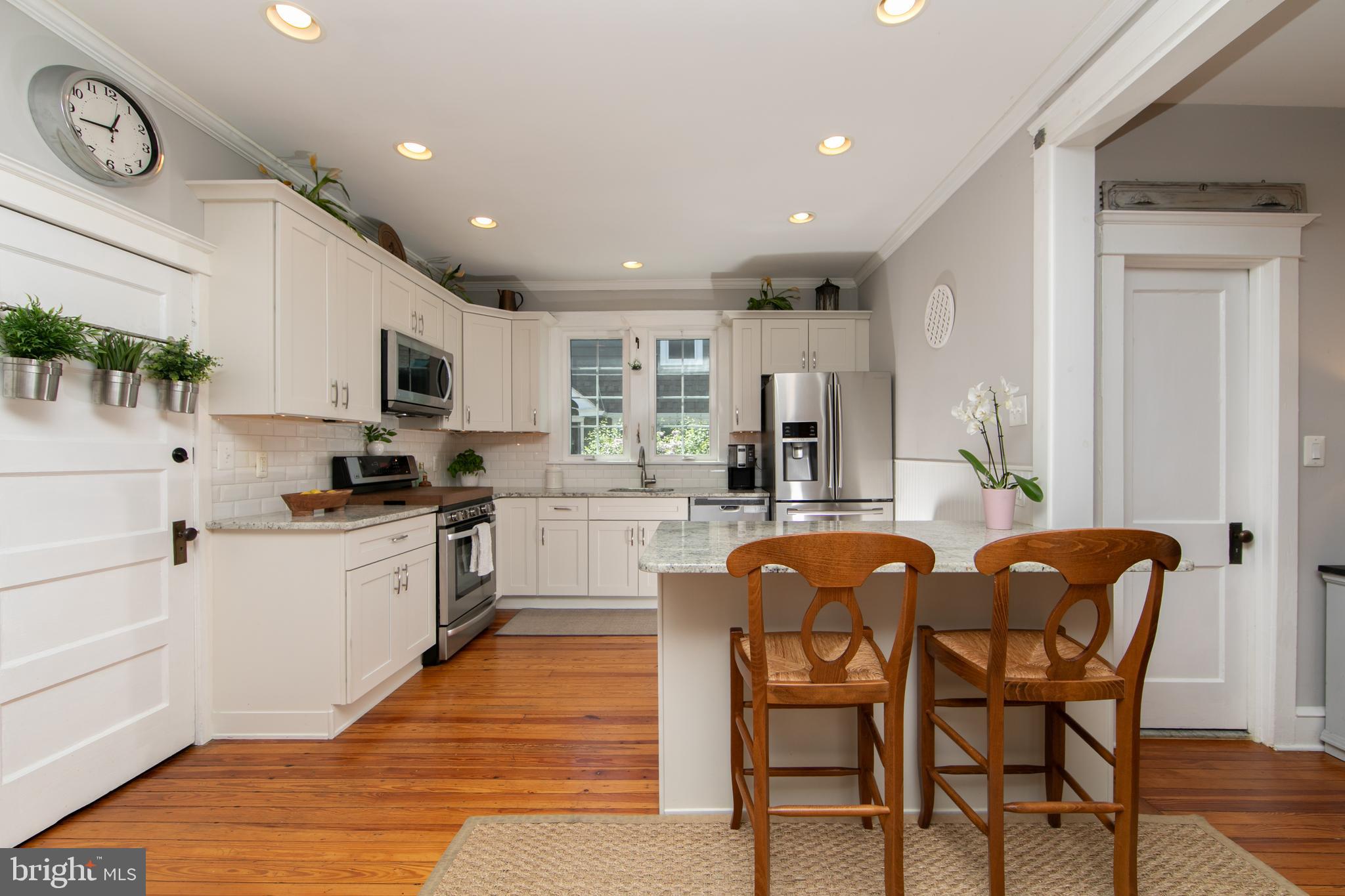 403 Belmont Avenue Haddonfield, NJ 08033 - Photo 15 of 47 a large kitchen with kitchen island a dining table chairs and a refrigerator