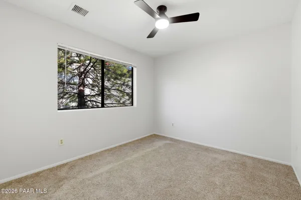 a bedroom with a bed a dresser and a window
