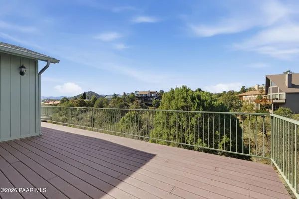 a view of empty room with wooden floor and ceiling fan