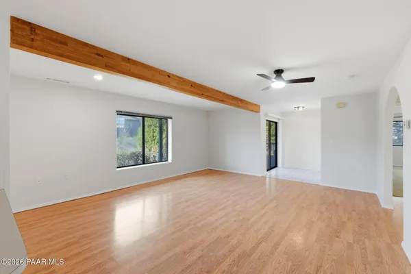 an empty room with windows and ceiling fan