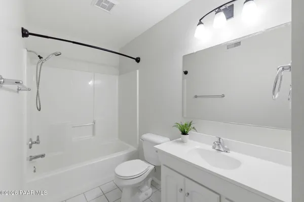 a view of an empty room and chandelier fan