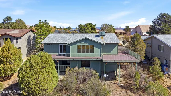 an aerial view of a house with a mountain