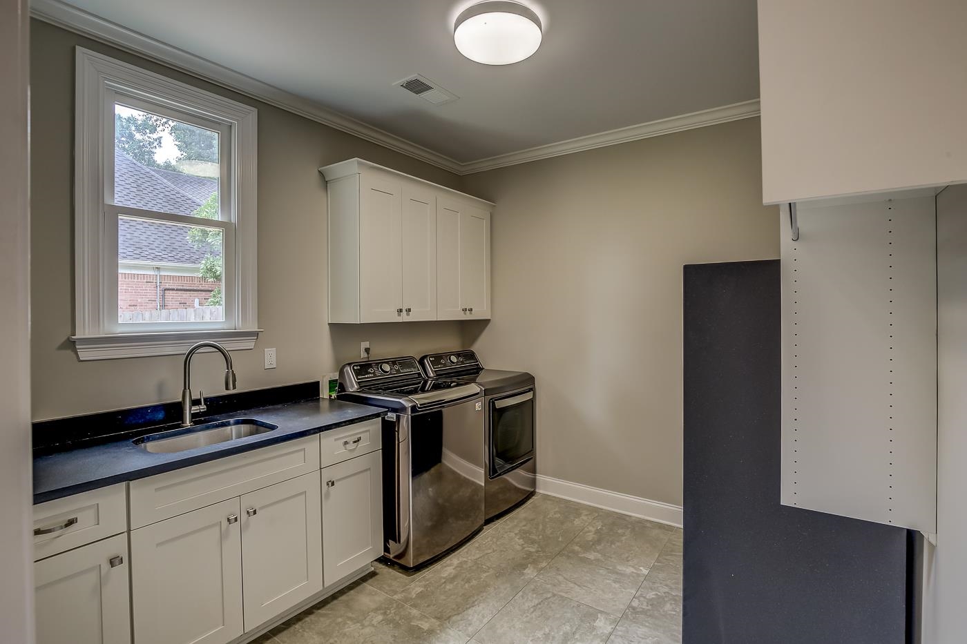1908 Riverdale Road Germantown, TN 38138 - Photo 12 of 40 Barn door entry. 2 piece crown molding. Custom tile floor. 5' x 9" deep mop sink at QUARTZ counter top/ base cabinet. Overhead cabinets and wall of built-in shelves. Freezer of additional refrigerator space.