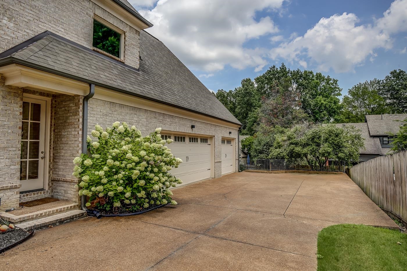 1908 Riverdale Road Germantown, TN 38138 - Photo 31 of 40 Friends Door just before 23x21 Double and 23x12 Single Car Garages. Wrought iron fence at end of driveway extends to gate to the left for access to back yard.