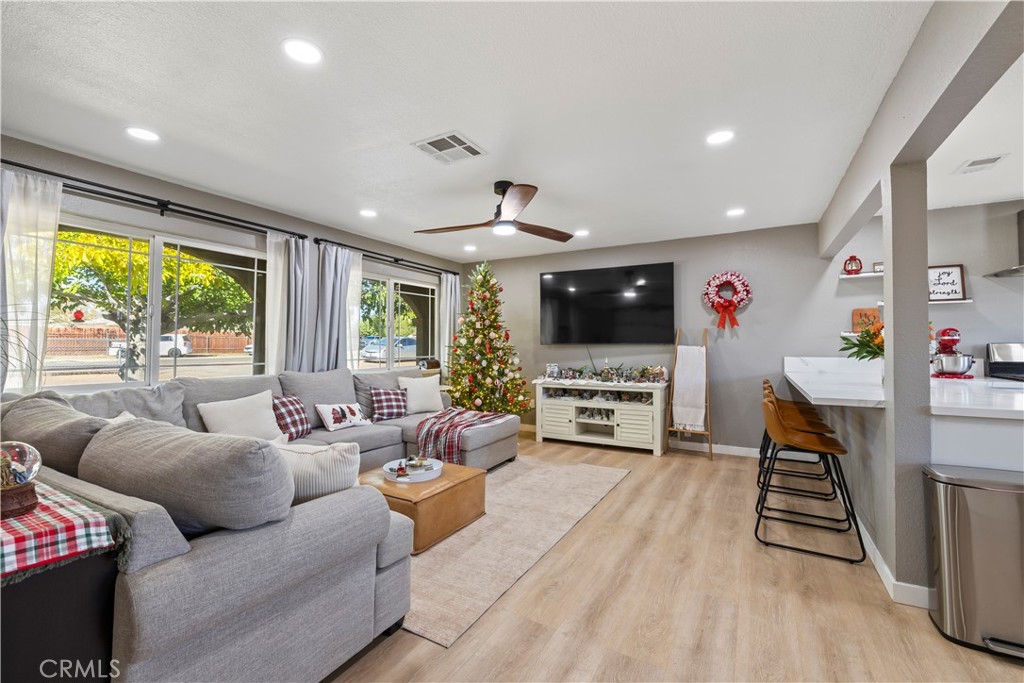 8755 Devon Avenue Hesperia, CA 92345 - Photo 2 of 45 a living room with furniture a flat screen tv and a floor to ceiling window