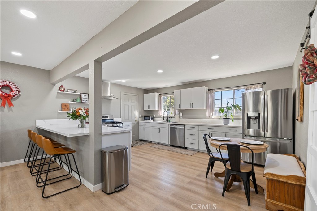 8755 Devon Avenue Hesperia, CA 92345 - Photo 7 of 45 a kitchen with a table chairs refrigerator and cabinets