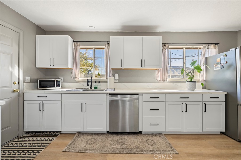 8755 Devon Avenue Hesperia, CA 92345 - Photo 10 of 45 a kitchen with granite countertop a sink stainless steel appliances and cabinets