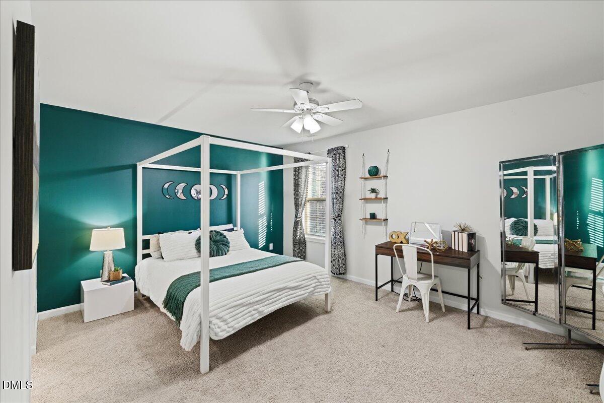 7804 Charters End Street Willow Spring, NC 27592 - Photo 30 of 43 a bedroom with a bed and a chandelier