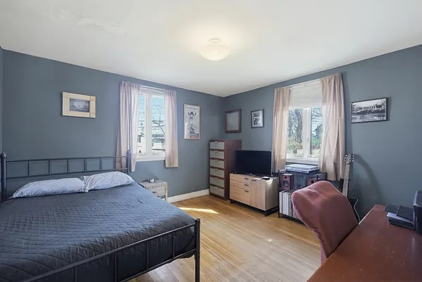 a bedroom with a bed and wooden floor