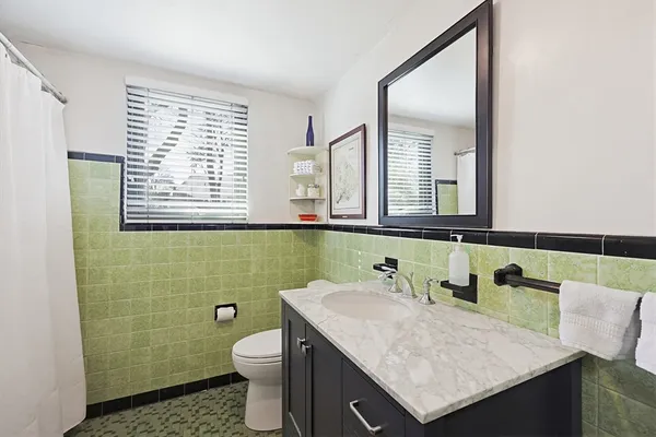 a bathroom with a granite countertop sink and a mirror