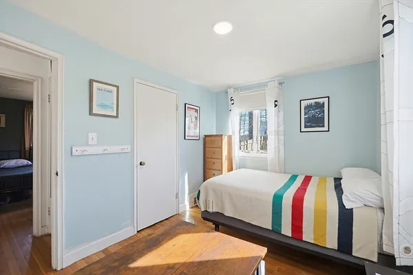 a bedroom with a bed and a painting on the wall