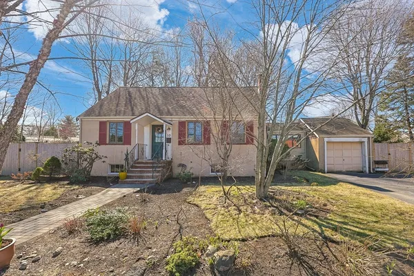 a front view of a house with a yard covered in snow