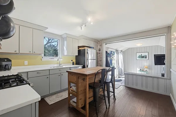 a kitchen with sink a stove and chairs