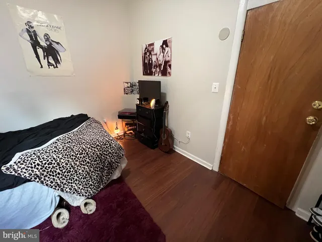 a bedroom with bed and wooden floor