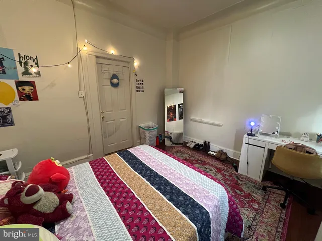 a bedroom with bed and wooden floor