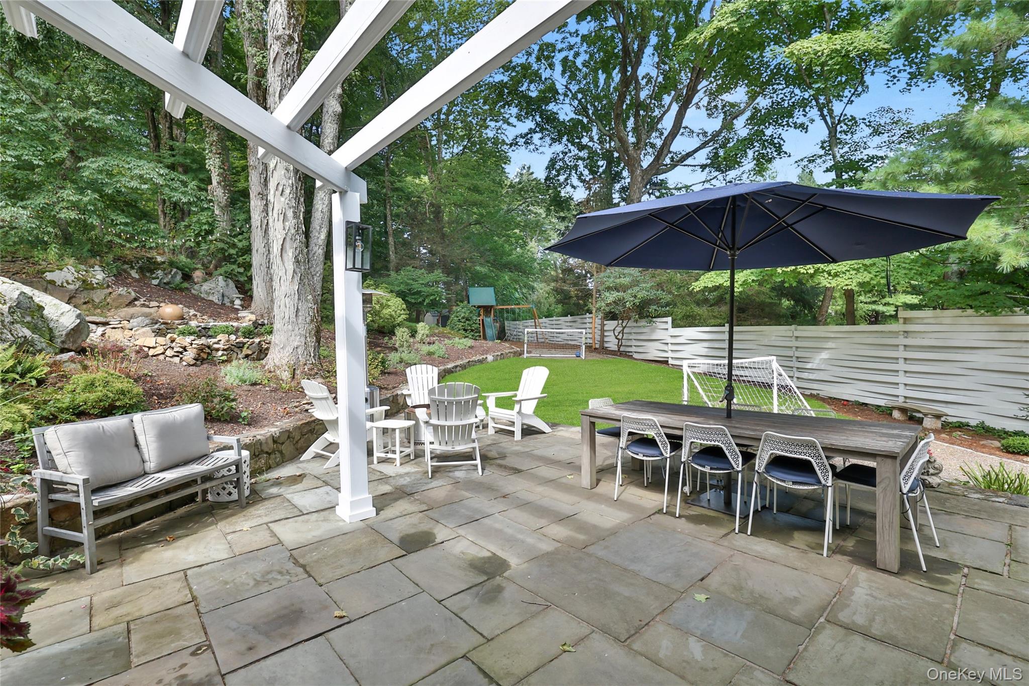 8 Old Roaring Brook Road Mount Kisco, NY 10549 - Photo 8 of 47 a view of an outdoor sitting area with furniture and umbrella
