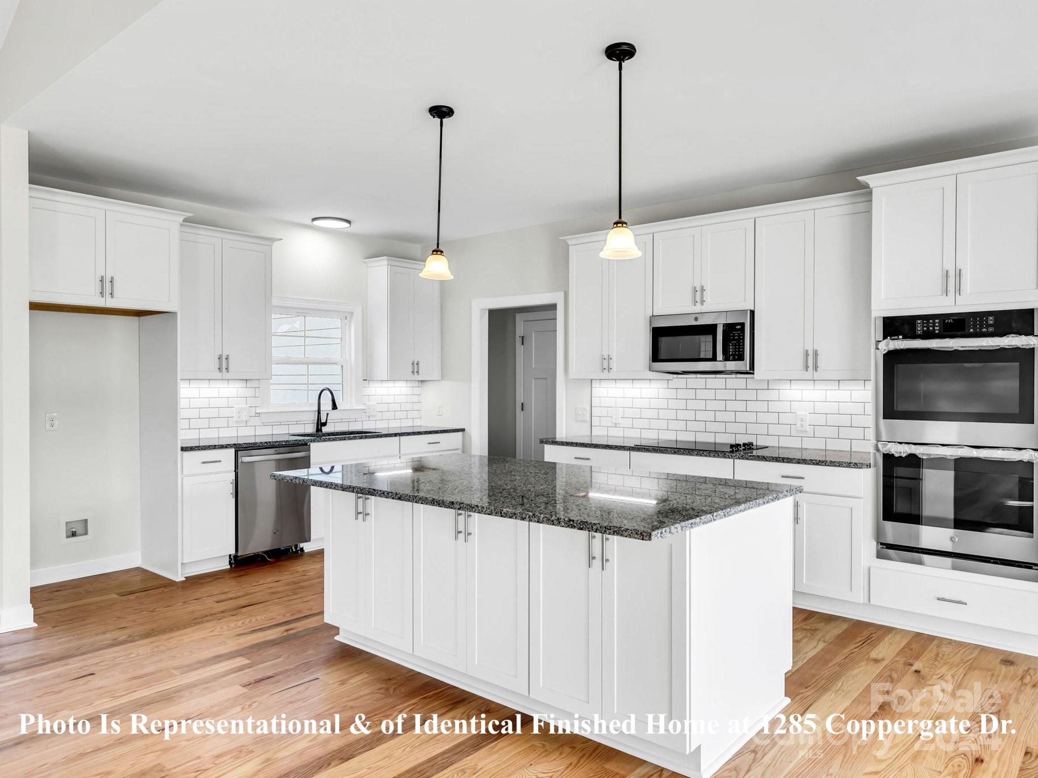 1375 Coppergate Drive Salisbury, NC 28147 - Photo 17 of 41 a kitchen with stainless steel appliances granite countertop a sink a stove a oven a refrigerator a center island and cabinets