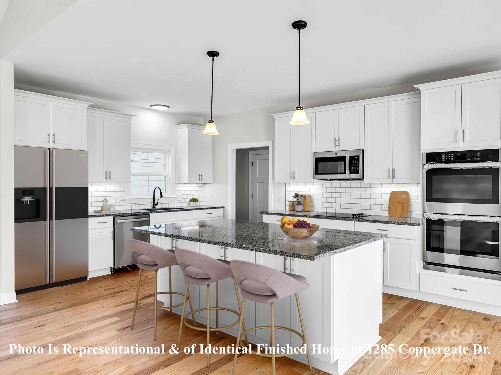 1375 Coppergate Drive Salisbury, NC 28147 - Photo 5 of 41 a kitchen with stainless steel appliances granite countertop a sink a stove a refrigerator a center island a stove and cabinets