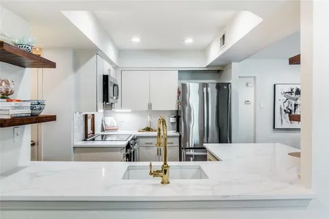 a kitchen with kitchen island sink and refrigerator