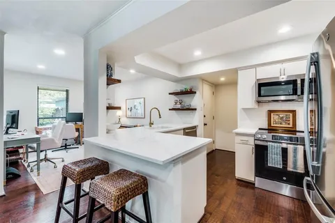 a large kitchen with a table chairs refrigerator and cabinets